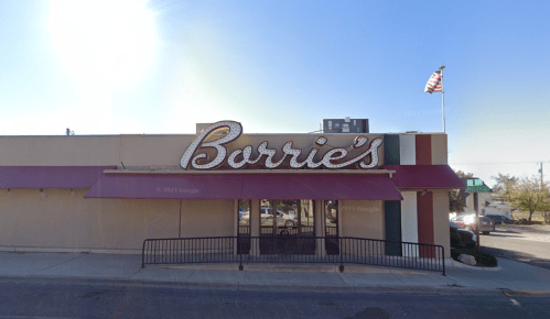 Exterior view of Burrie's restaurant with a large sign and awning, featuring an American flag in the background.