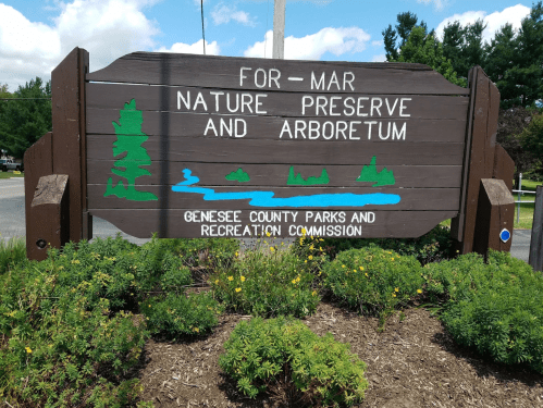 Sign for For-Mar Nature Preserve and Arboretum, featuring trees, a river, and information about Genesee County Parks.