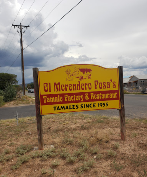 Sign for El Merendero Posa's Tamale Factory & Restaurant, established in 1955, with a cloudy sky in the background.