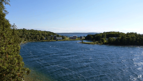 A serene view of a river winding through lush greenery under a clear blue sky.
