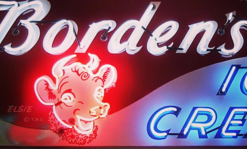 Neon sign for Borden's Ice Cream featuring a cartoon cow's face and the name "Elsie" in bright colors.