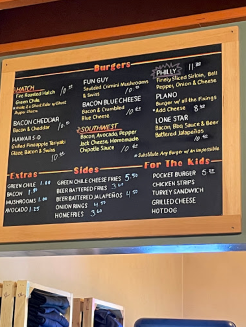 Menu board featuring burger options, sides, and extras with prices listed.