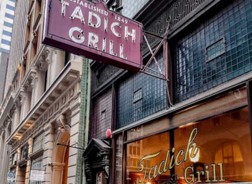Sign for Tadich Grill, established in 1849, displayed on a historic building in an urban setting.