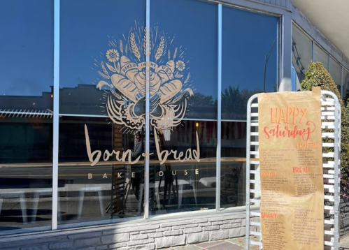 A storefront with large windows displaying the "Born & Bread Bakehouse" logo and a menu sign for Saturday specials.