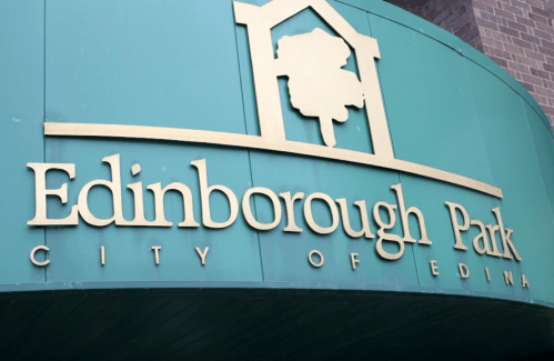 Sign for Edinborough Park, featuring the name and "City of Edina" in gold lettering on a green background.