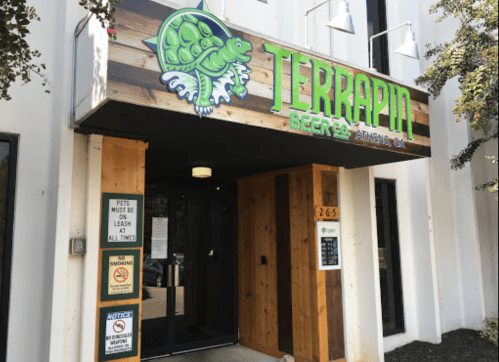 Exterior of Terrapin Beer Company in Athens, GA, featuring a wooden sign with a turtle logo and entrance doors.