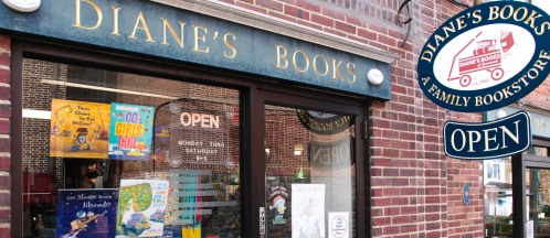 Exterior of Diane's Books, a family bookstore, featuring a sign that says "Open" and colorful book displays in the window.