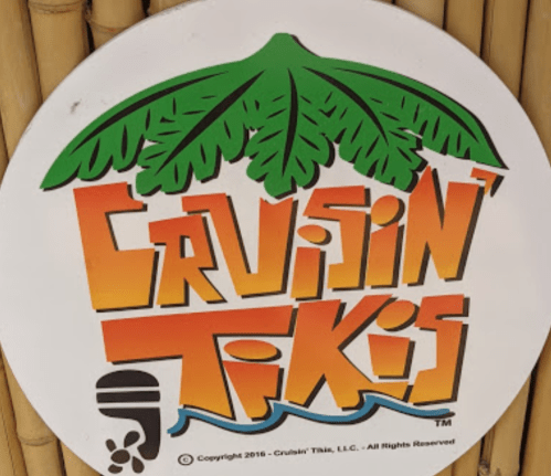 Colorful logo for "Cruisin' Tikis" featuring palm leaves and vibrant text on a circular white background.