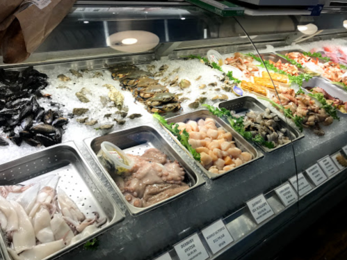 A seafood display case filled with various fresh seafood on ice, including fish, shellfish, and shrimp.