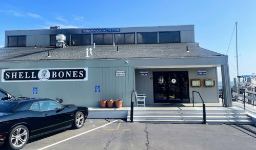 Exterior of Shell Bones restaurant with a black car parked outside and the Pequonnock Yacht Club sign above.