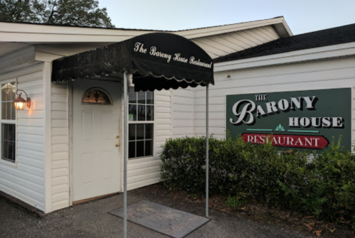 Exterior of The Barony House Restaurant, featuring a covered entrance and a sign with the restaurant's name.