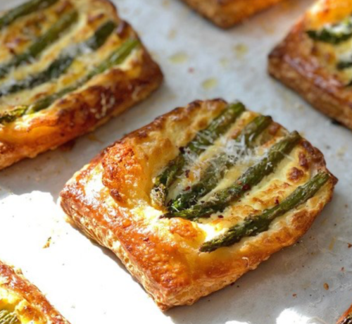 Golden puff pastry topped with asparagus and cheese, baked until crispy and golden brown.