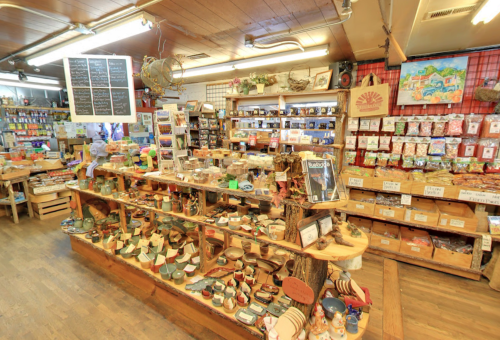 A cozy shop interior filled with various crafts, wooden items, and colorful packaged goods on display.