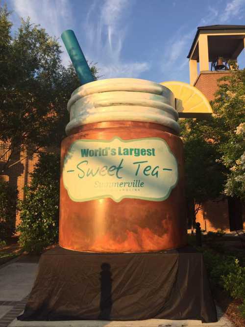 A large, decorative sweet tea cup with a straw and lemon, labeled "World's Largest Sweet Tea" in Summerville, SC.