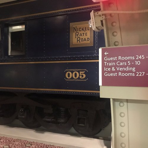 A vintage train car labeled "Nickel Plate Road" with a sign indicating guest room numbers and train car details.