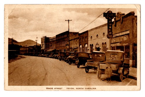 Vintage postcard of Trade Street in Tryon, North Carolina, featuring old cars and historic buildings.