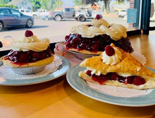 Three delicious desserts: a cherry pie, a mini cherry pie, and a slice of pastry topped with cherries and whipped cream.