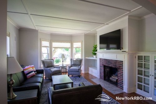 Cozy living room with a fireplace, modern furniture, and a large window letting in natural light.