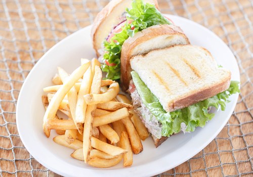 A plate with a sandwich made of toasted bread, lettuce, and tomato, accompanied by a side of golden French fries.
