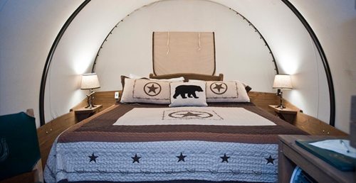 Cozy bedroom with a round design, featuring a large bed, decorative pillows, and soft lighting from bedside lamps.
