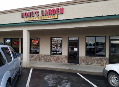 Exterior of Hong's Garden Chinese Restaurant, featuring a sign and large windows, with parked cars in front.