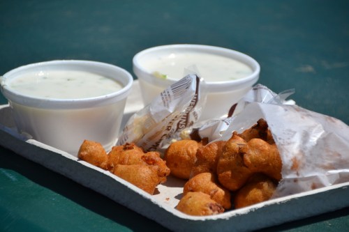 A tray with two bowls of soup and a serving of fried snacks, all on a green table.