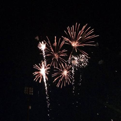 Colorful fireworks burst in the night sky, illuminating the darkness with vibrant sparks and trails.