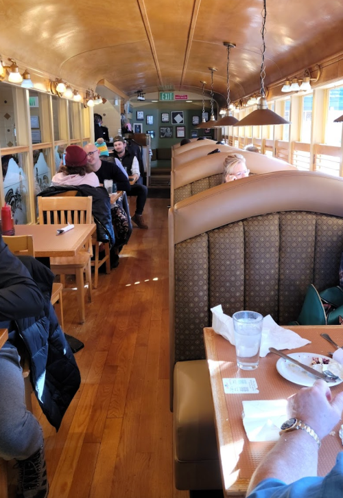 Interior of a diner with wooden booths, patrons seated, and a warm, inviting atmosphere.