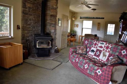 Cozy living room with a stone fireplace, patterned couch, and wooden furniture, creating a warm, inviting atmosphere.