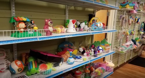Colorful shelves filled with various children's toys, including musical instruments and plush characters.