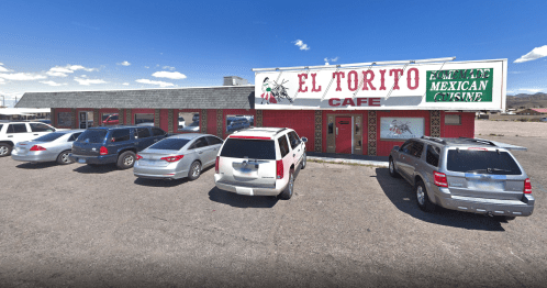 Exterior of El Torito Cafe, a Mexican restaurant, with several parked cars in front and a clear blue sky.