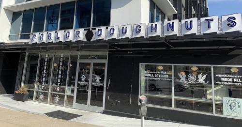 Exterior of Parlor Doughnuts, featuring a modern storefront with large windows and a sign above the entrance.