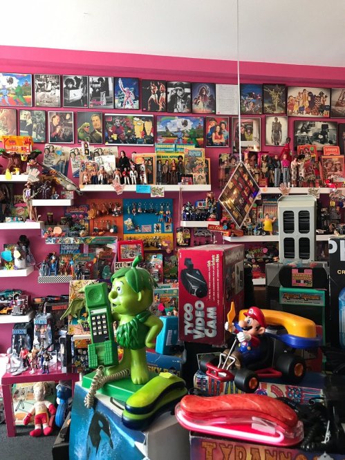 A colorful display of vintage toys and memorabilia, featuring action figures, posters, and playful decor.