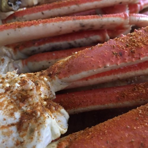 Close-up of seasoned crab legs, showcasing their vibrant red color and texture.