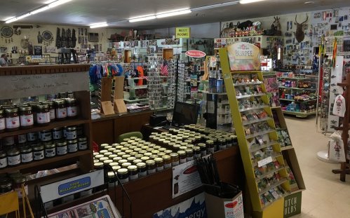A cozy store interior filled with shelves of products, jars, and various items for sale, creating a welcoming atmosphere.