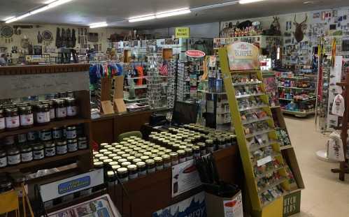 A cozy store interior filled with shelves of products, jars, and various items for sale, creating a welcoming atmosphere.