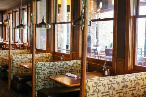 Cozy restaurant interior with wooden booths, large windows, and stylish lighting, creating a warm atmosphere.
