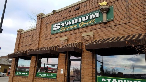 Exterior of Stadium Sports Grill, featuring a brick facade and large green signage.