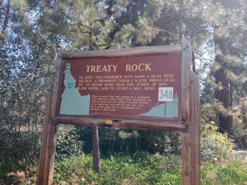 Sign at Treaty Rock detailing a historical agreement involving the Coeur d'Alene Indian Tribe and land use.