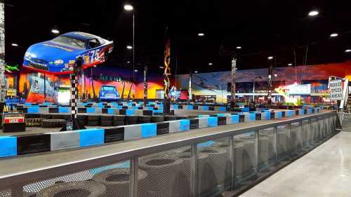 Indoor go-kart track with colorful murals, racing cars, and a vibrant atmosphere.