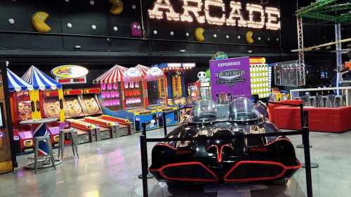 A retro arcade with colorful game booths and a classic black car in the foreground, under a neon "ARCADE" sign.