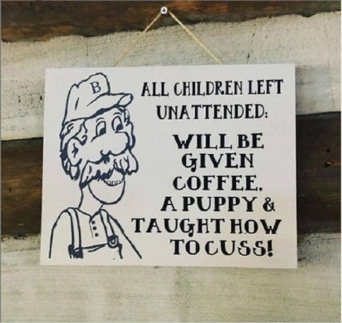 A humorous sign featuring a cartoon man, stating unattended children will get coffee, a puppy, and learn to curse.
