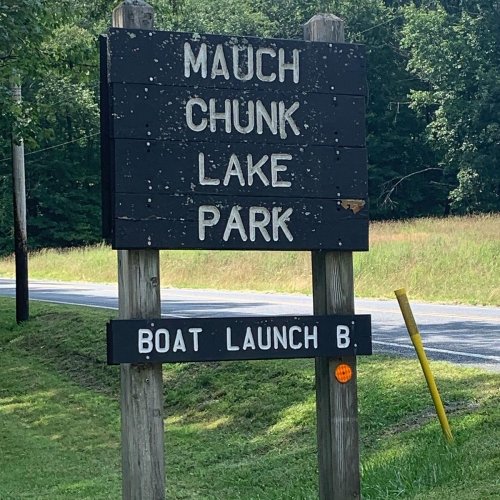 Sign for Mauch Chunk Lake Park with directions to Boat Launch B, surrounded by greenery and a road.