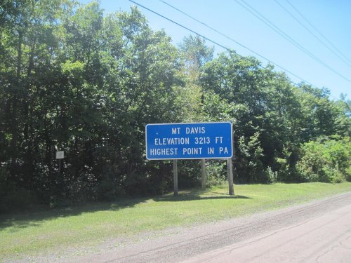 Sign for Mt. Davis, elevation 3213 ft, indicating it is the highest point in Pennsylvania, surrounded by greenery.