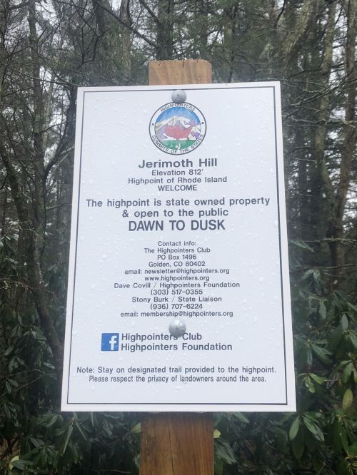 Sign for Jerimoth Hill, Rhode Island, indicating it's a public highpoint open from dawn to dusk. Contact info included.