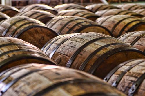 A close-up view of wooden barrels stacked closely together in a storage area.