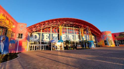Colorful exterior of a building with large windows and the word "DEZERLAND" prominently displayed. Clear blue sky above.