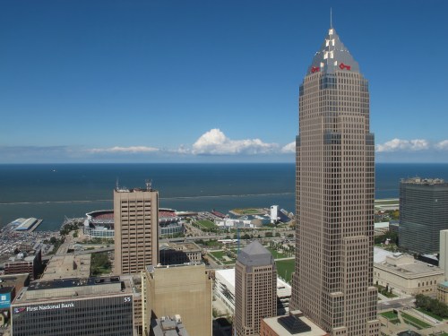 Aerial view of Cleveland's skyline with the lake in the background and a clear blue sky.
