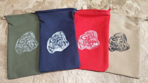 Four drawstring bags in green, blue, red, and beige, each featuring a unique graphic design.