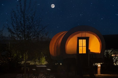 A glowing wagon under a starry night sky, with a bright moon illuminating the scene.